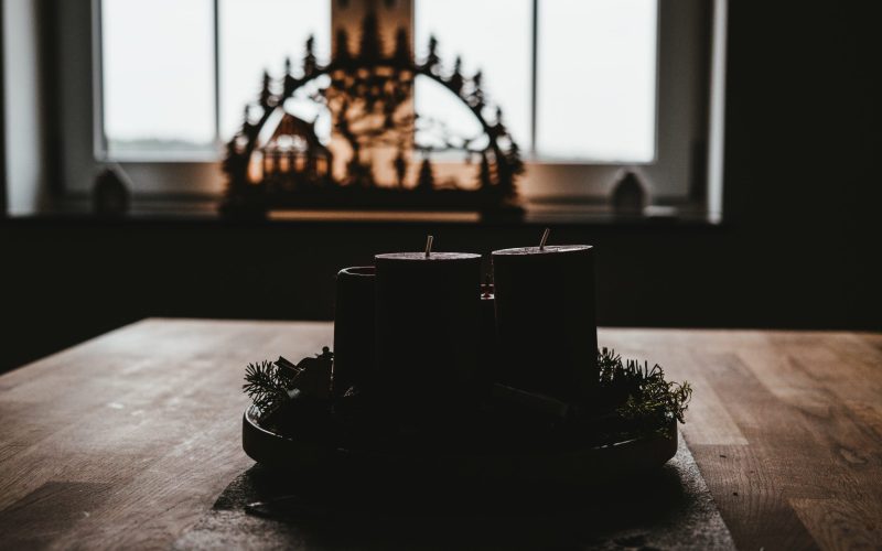 four black pillar candles on top of table