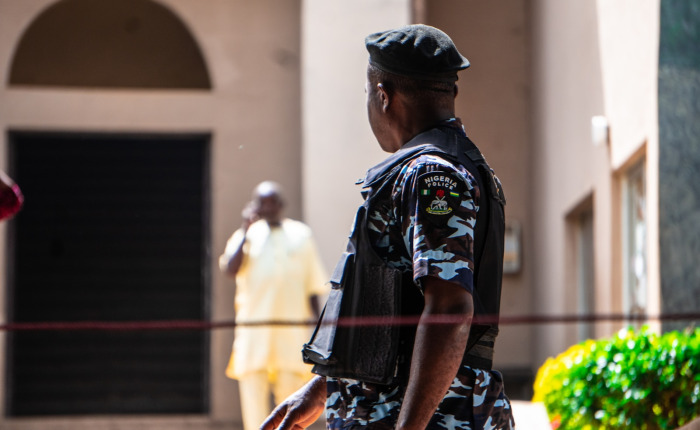A couple of men standing next to each other in front of a building